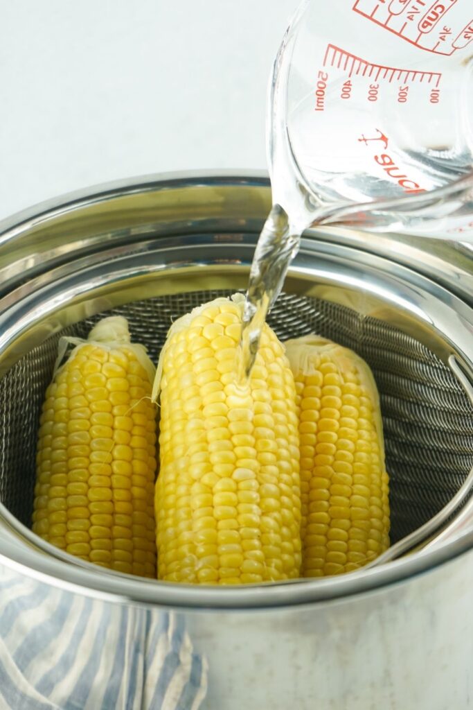 pouring water over corn in Instant Pot 