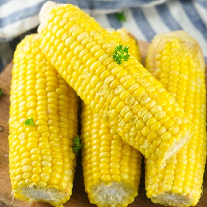 corn on the cob on wooden cutting board 