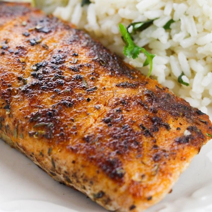 Grill pan with delicious salmon steaks on stove in kitchen Stock