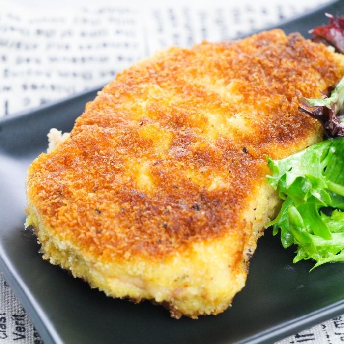 pork chop on a plate with salad by it 