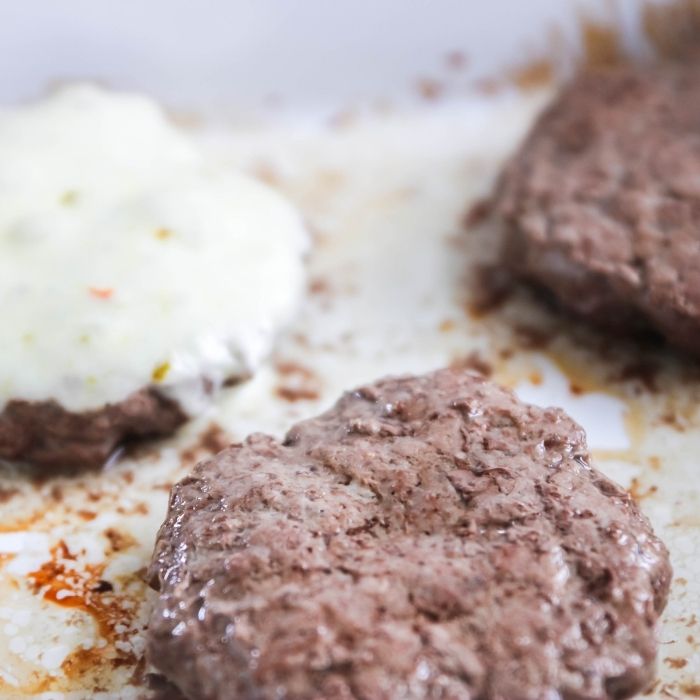 side view of burgers in pan cooked 