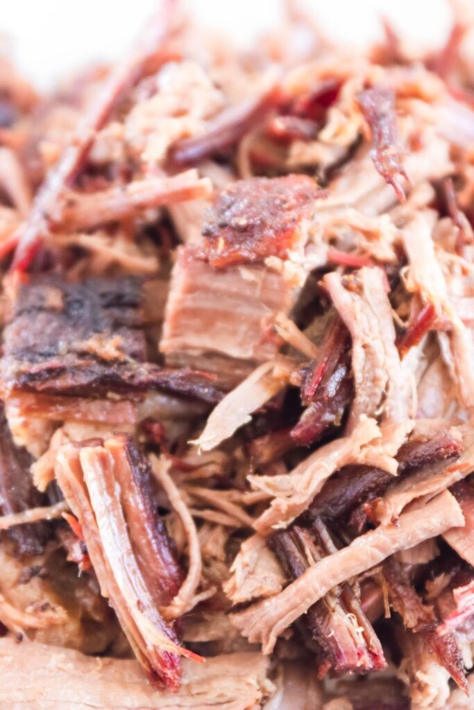 shredded pork on cutting board 