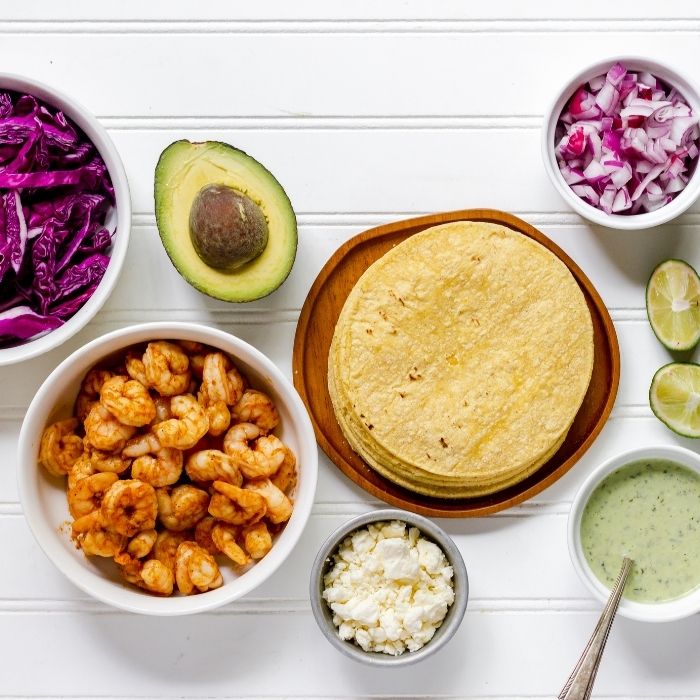 ingredients for shrimp taco on white table 