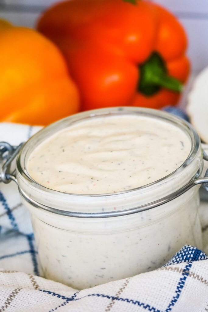 Mexican dressing in a jar on table with towel