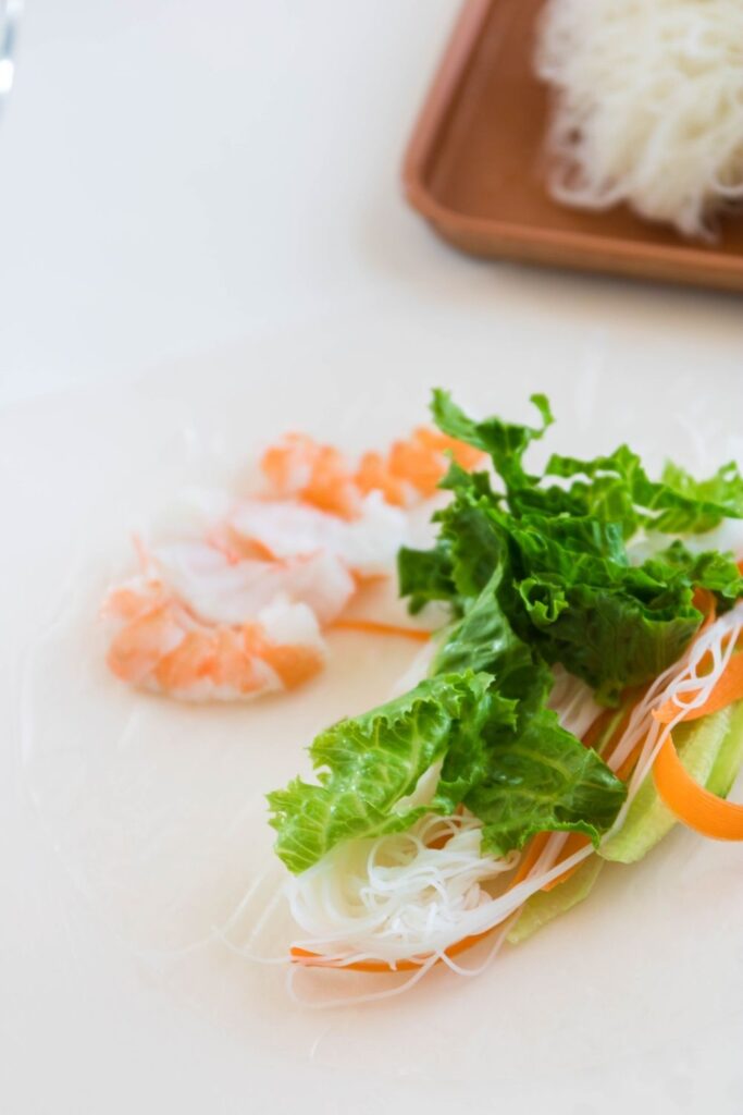 spring roll on a cutting board  filled with vegetables and shrimp 