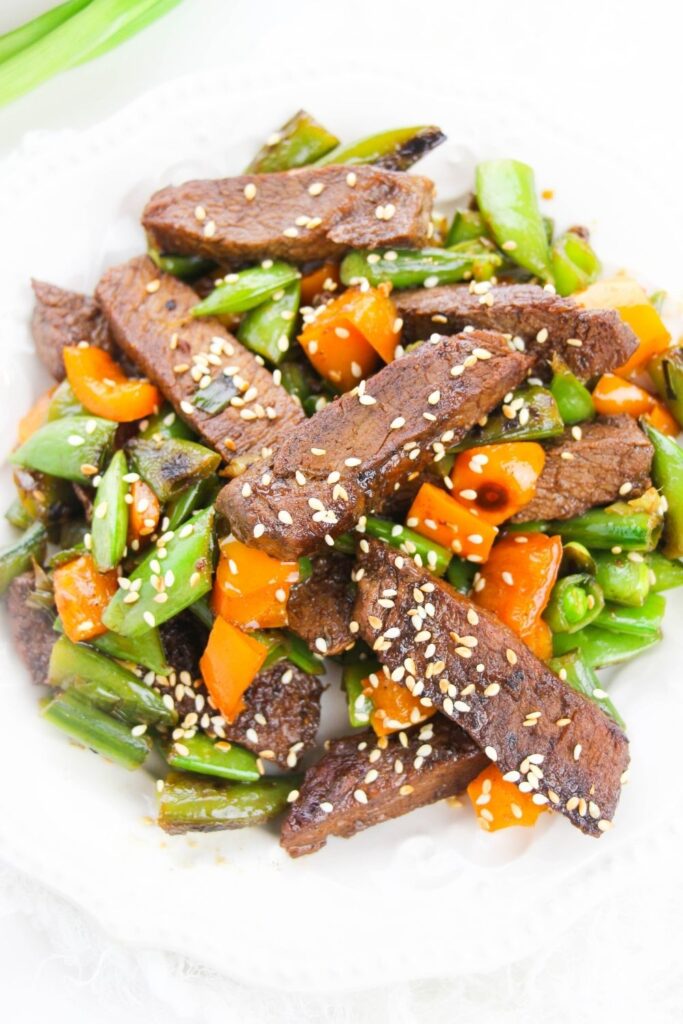 steak and vegetable stir fry on white plate 