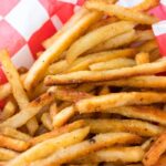 french fries in a basket on white table