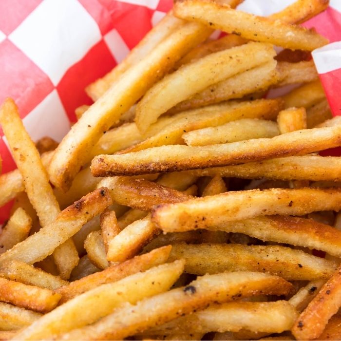 french fries in a basket on white table 