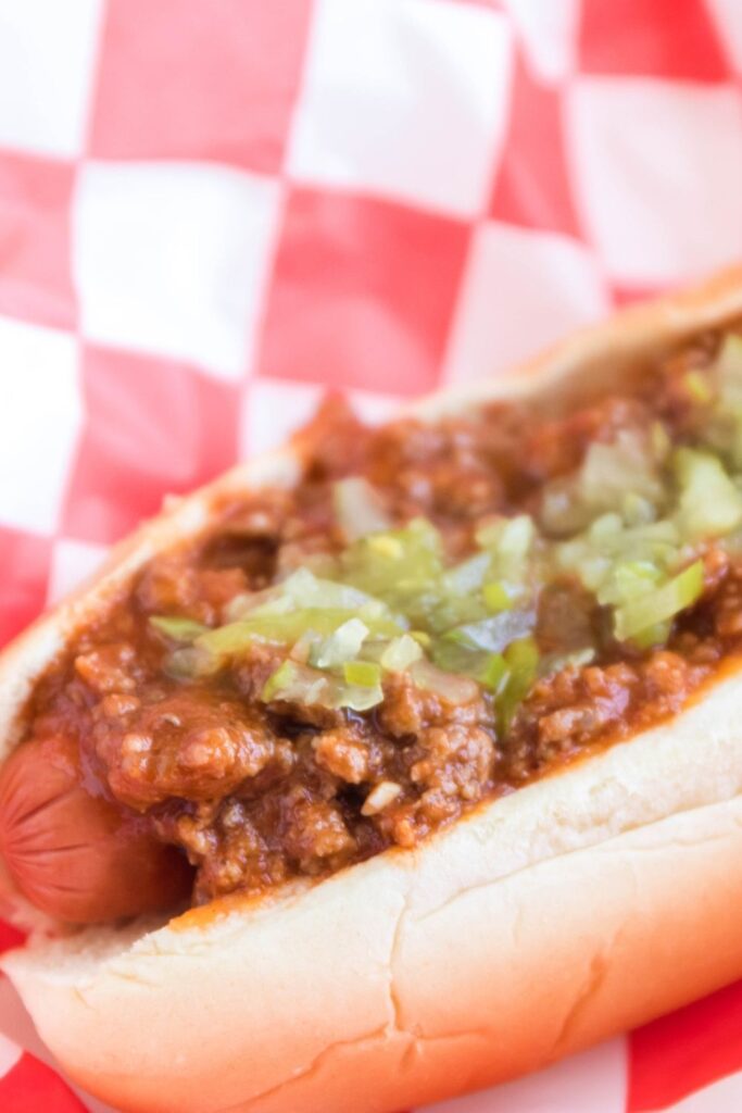 close up of hot dog in bun with chili and relish