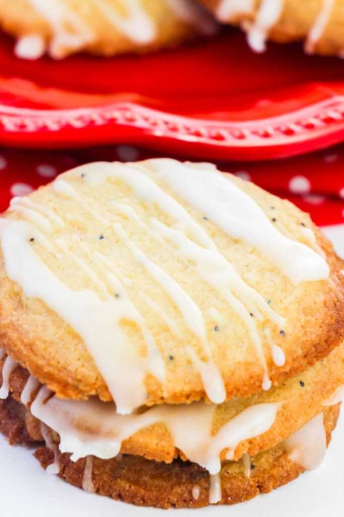 poppy seed cookies on counter with cookies on plate behind it 