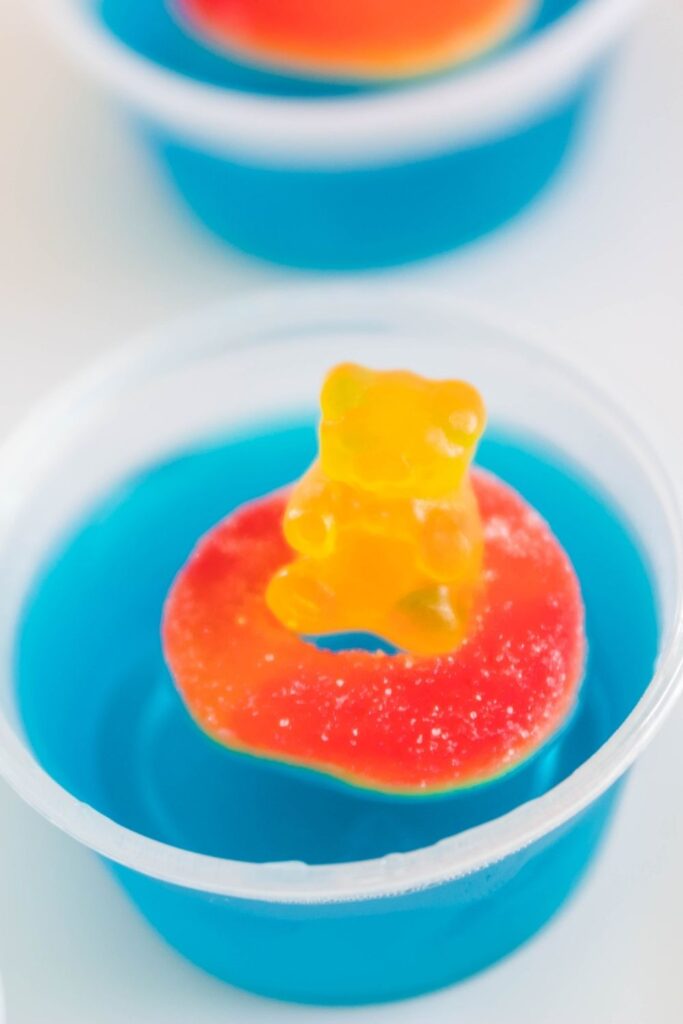 side view of blue jello shot with gummy candies on top 