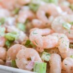 cold shrimp salad in a serving bowl on white table