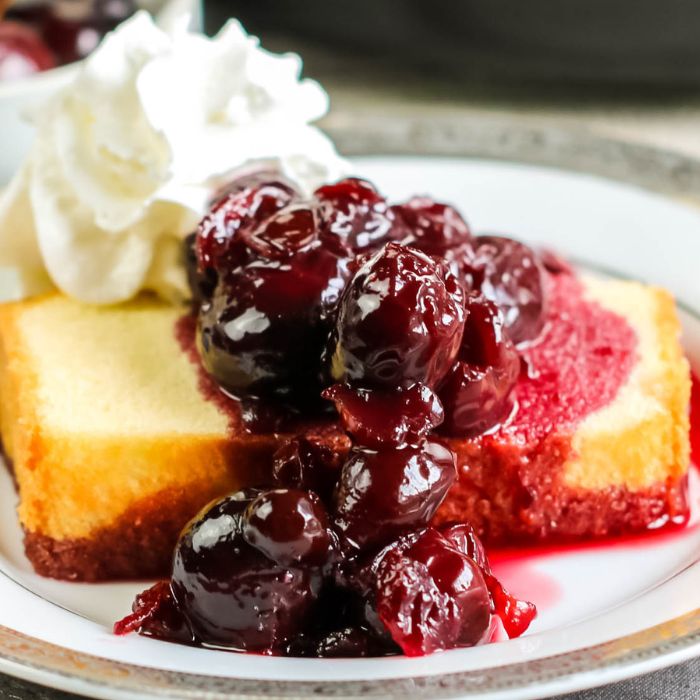 pound cake with cherries jubilee on plate with whipped cream 