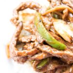 pepper steak on a plate with bed of rice