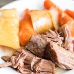 roast with potatoes and carrots on plate