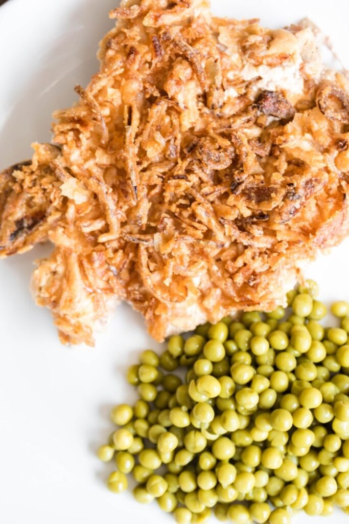 french onion pork chop and peas on plate