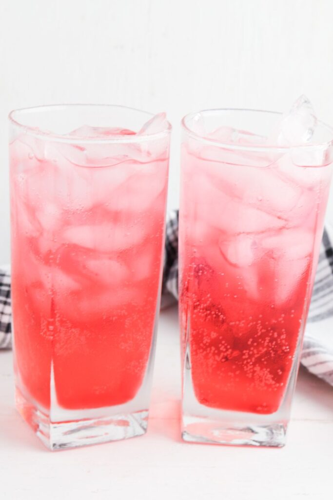 two shirley temple drinks in glasses on white table 