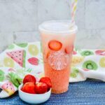 Starbucks Pink Drink on table with bowl of strawberries on table