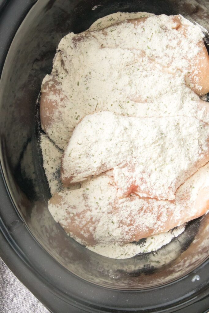 chicken in crockpot with ranch powder over the top of it