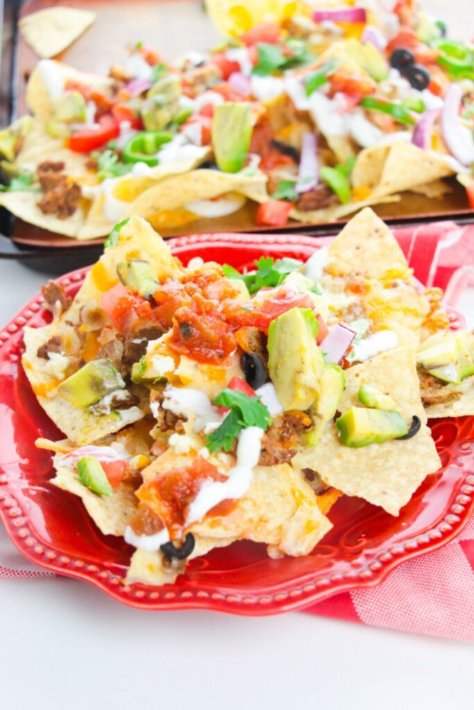 homemade nachos on a red plate 