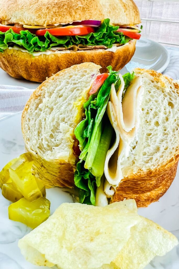 party sub on plate with chips and pickles 