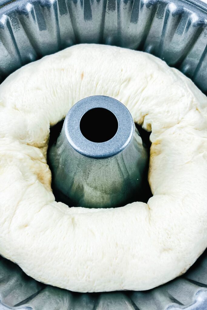 raw bread dough in a bundt pan shaped like a ring 