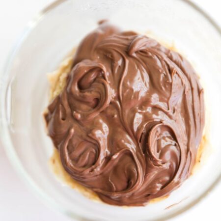 overhead shot of protein mug cake in clear glass with Nutella on top