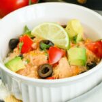 bowl of mexican chicken and taco toppings on top