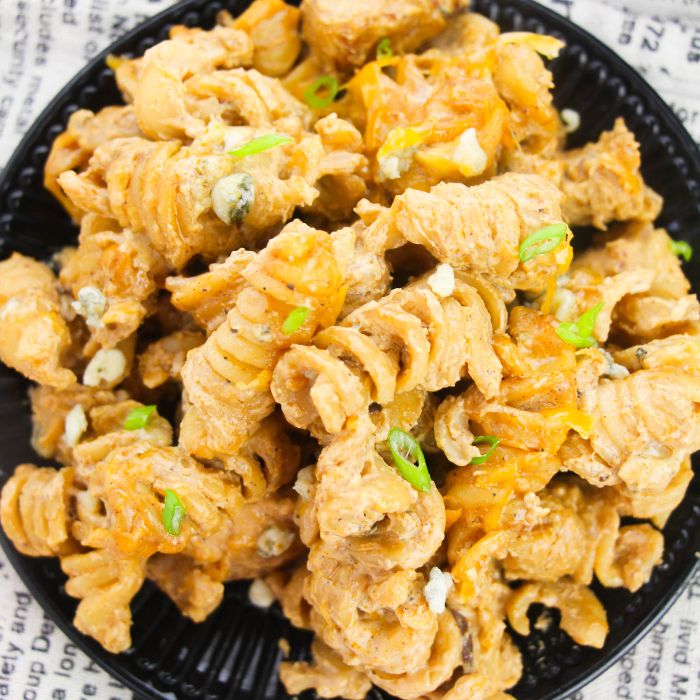 Buffalo Chicken Pasta on a black plate on a table 