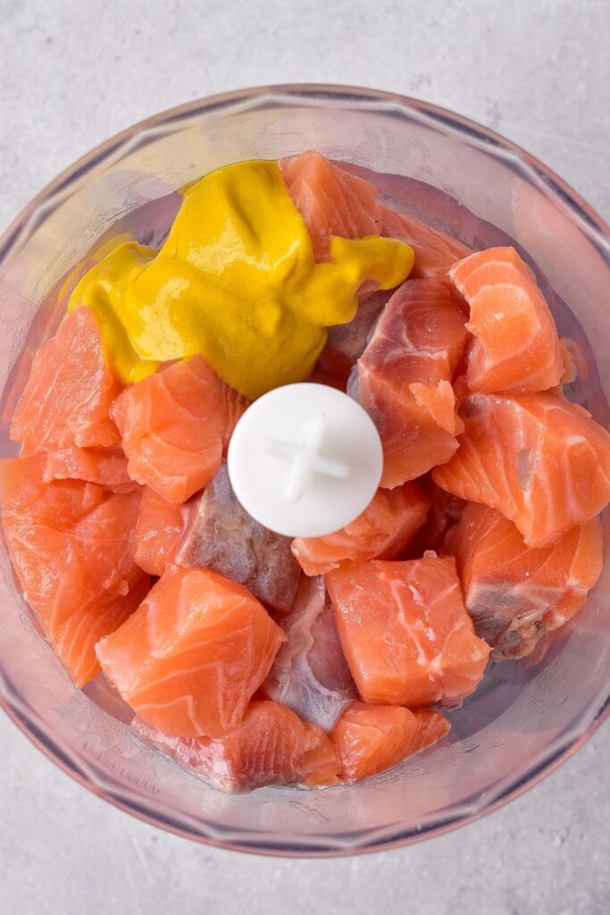 salmon and mustard in a food processor on table 