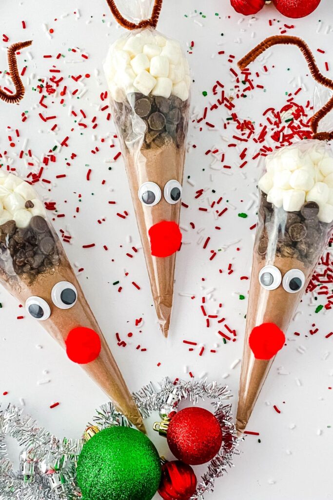 reindeer hot chocolate pouches on white counter with christmas decor around it