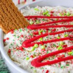 bowl of Christmas tree cake dip with sprinkles and chocolate drizzled on top