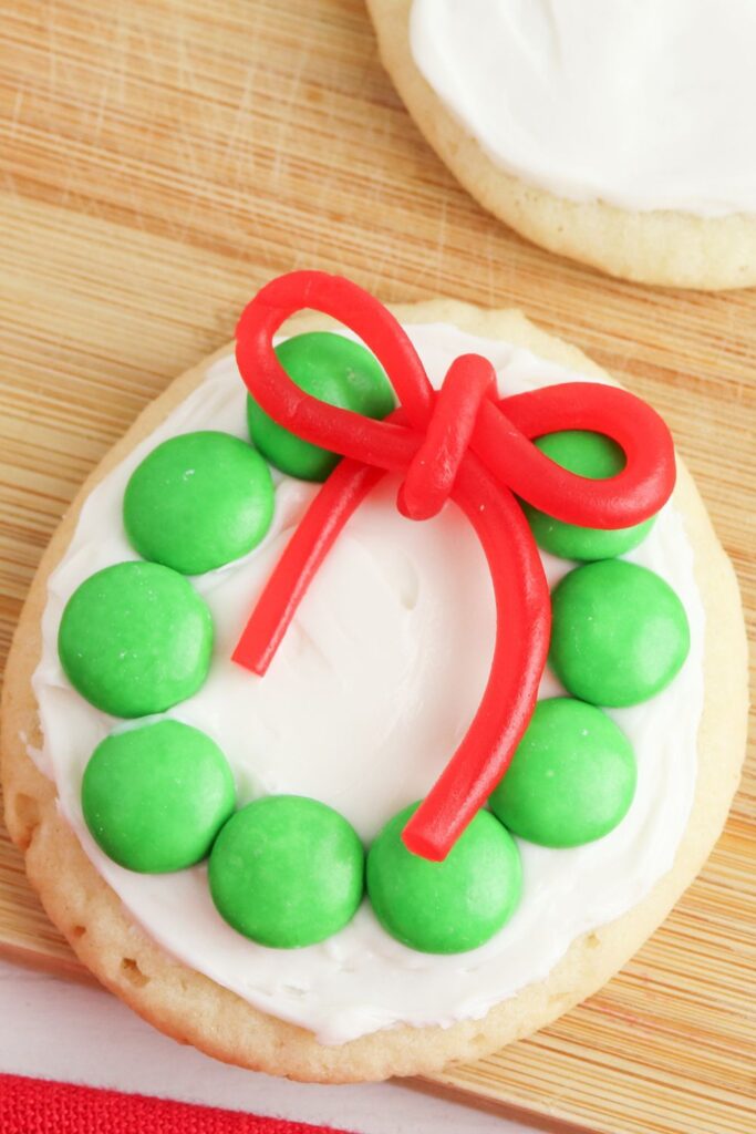 Christmas wreath decorated cookies on wooden cutting board 