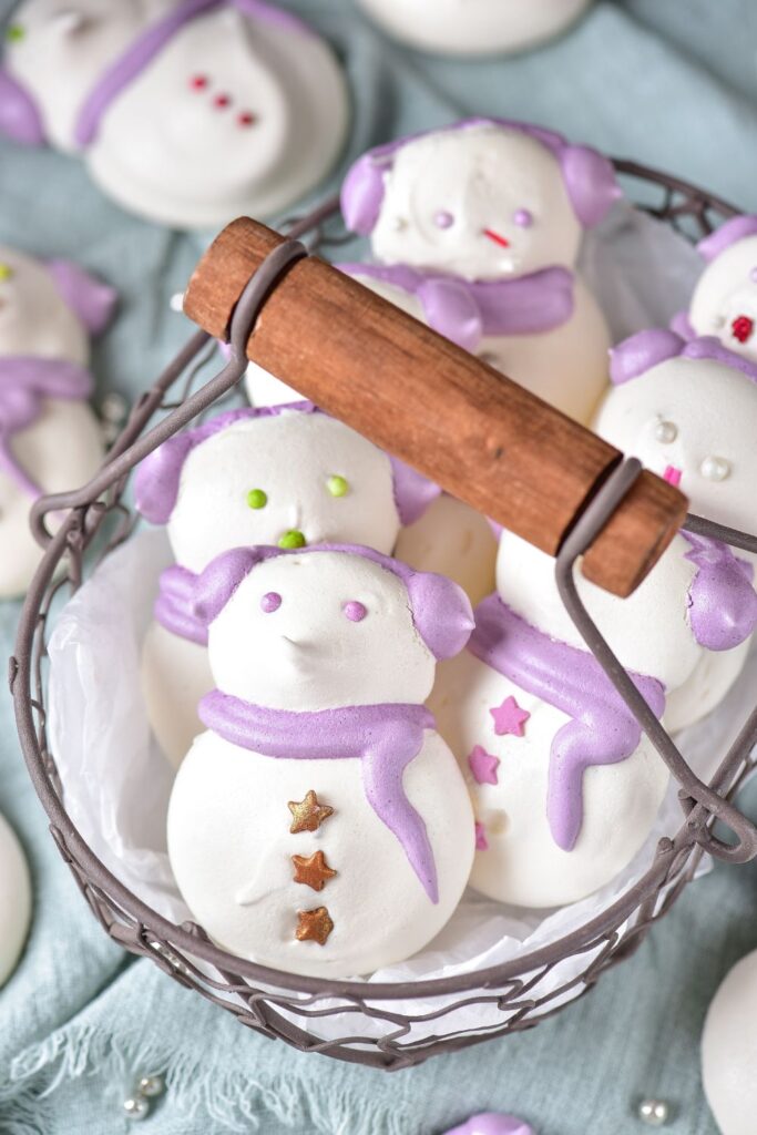 vanilla meringue cookies shaped like snowman in a wire basket