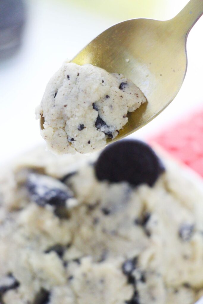 edible cookie dough on spoon above a bowl