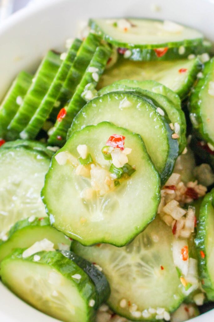 close up of Korean cucumbers in a bowl with red pepper flakes 
