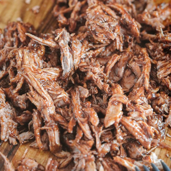 bbq pulled pork on a wooden cutting board