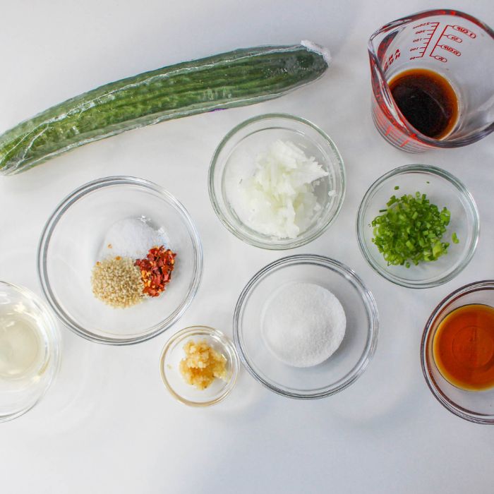 ingredients for korean cucumbers on white counter in glass bowls 