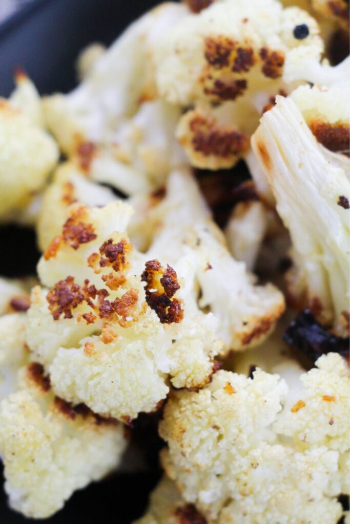 roasted cauliflower on a black plate 