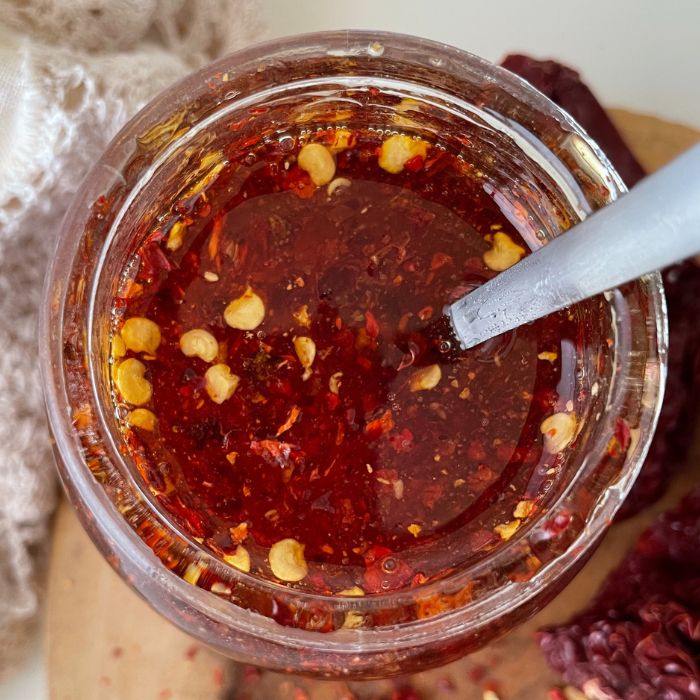 overhead shot of honey with red pepper flakes in it and a spoon in the bowl