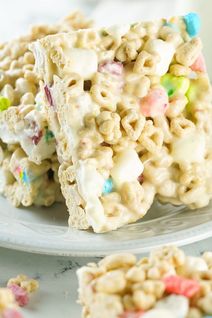 lucky charms treats sliced into squares on plate and bars on table 