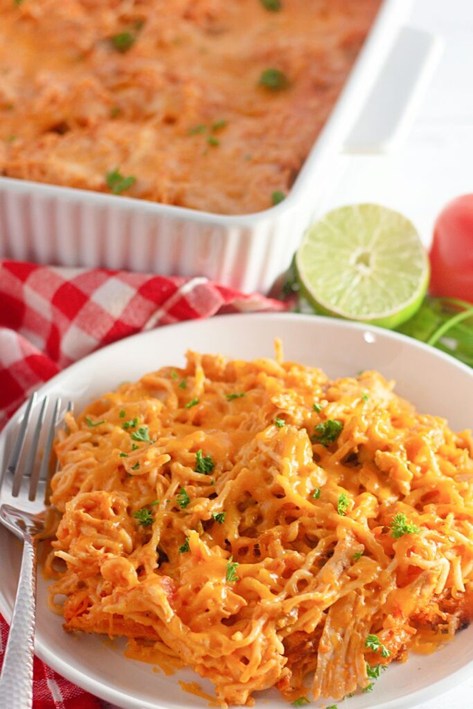 plate with a mexican pasta bake and then in the background a cut lime and casserole dish 