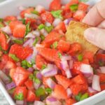 strawberry salsa in a bowl with chip dipping in bowl