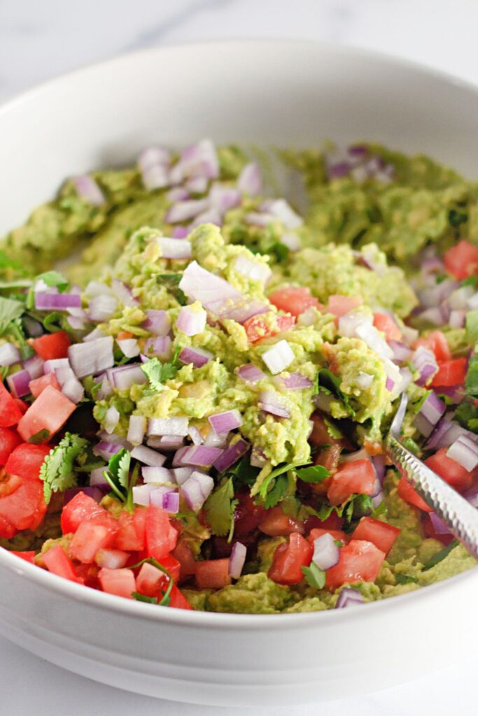 mixing up guacamole in a bowl