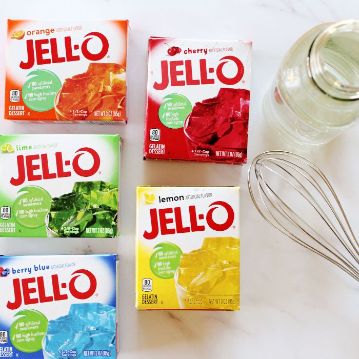 jello boxes on marble counter with whisk and container of water