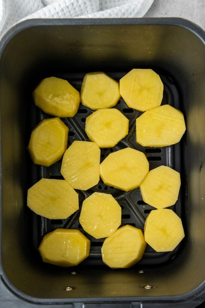 accordion style potatoes in an air fryer basket 