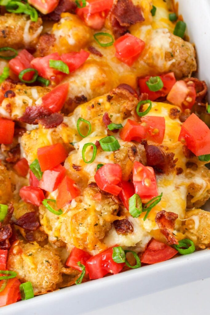 chicken tater tot casserole in pan with a spatula lifting some of it out of pan 