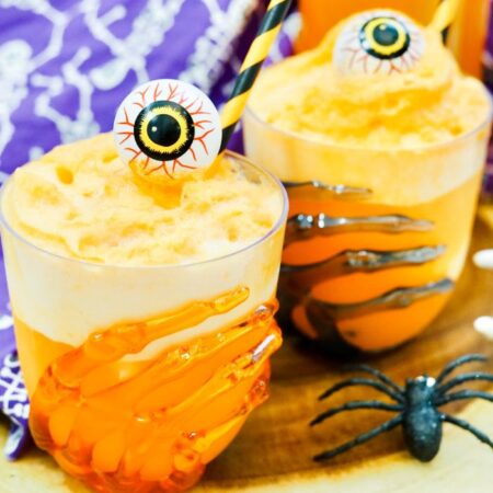 two fanta floats on table in Halloween glasses topped with a candy eye