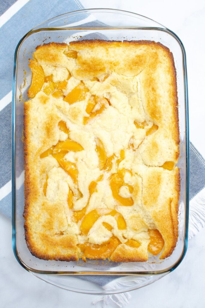 peach cobbler baked in a casserole dish sitting on table