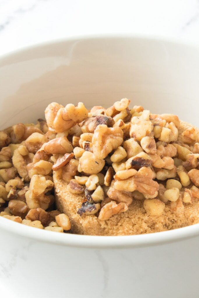 brown sugar and walnuts in a small white bowl on table 